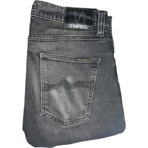 LEAN DEAN JEANS från NUDIE JEANS - Säljer ett par stilrena Nudie Jeans i en mörkgrå färg med subtila ljusgrå nyanser. Perfekt passform och kvalitet för en modern och tidlös look. Storlek 30/34, i mycket fint skick!  Tveka inte att höra av dig vid eventuella frågor✨