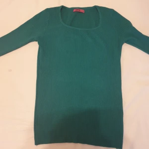 Tröja - Grön stickad tröja med rund halsringning. Tröjan är långärmad och har en rak passform. Säljs för 40