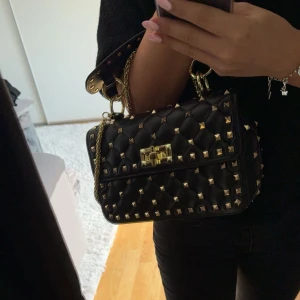 Svart väska - Jag säljer denna Valentino liknande väskan. Väskan är helt oanvänd då den inte kommit till användning.