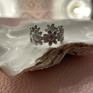 Fin ring med blommor - En fin ring med blommor, den är inte äkta men står att den är rostfritt stål. Juster bar vilket gör det lätt att göra större och mindre. Och kan passa på flera! Säljer då den inte kommer till användning.
