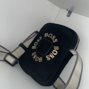 Hugo boss  - Enu en Hugo boss väska som it finns på marknaden längre finns lite skador på bandet som man har runt Axel annars inget mer en så 