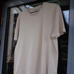 T-shirt  - Beige tröja från These Glory Days. XL. Tight fit. Stretch. Inte mycket använd. Kolla gärna profilen. Säljer gärna flera plagg samtidigt. Frakt tillkommer. 