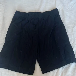 Svarta shorts från H&M x Netflix - Säljer ett par svarta shorts från H&M i samarbete med Netflix. De har en elastisk midja för en bekväm passform. Perfekta för en avslappnad stil.