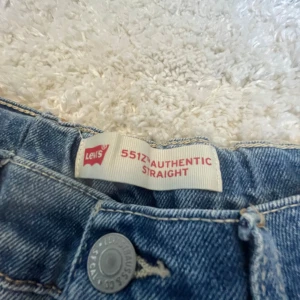 Levi's 551Z Authentic Straight Jeans - Säljer ett par klassiska Levi's 551Z Authentic Straight jeans i blå denim. De har en rak passform och är perfekta för en avslappnad stil. Jeansens design inkluderar den ikoniska Levi's-lappen och en knappgylf.