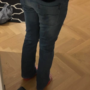 lowwaist bootcut jeans - ljusblåa lowwaist bootcut. jätte fina men har en liten fläck (går nog bort i tvätten) och ett litet hål. den har ingen guld utan är stängd hela vägen. står ingen storlek men jag är strl s o de passar mig bra.