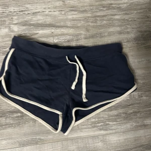 Mörkblå shorts med vita detaljer - Snygga mörkblå shorts med vita kanter och snörning i midjan. Perfekta för en avslappnad stil. det är bekväma att bära.