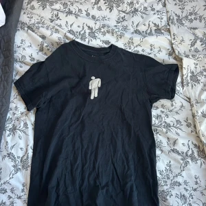 Svart t-shirt med tryck  - Säljer en svart t-shirt frpn billie eilish äldre merch med tryck på framsidan. Endast använd några få gånger🩶