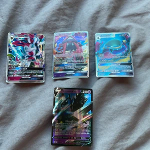 Pokémon GX och V-kort - Samling av Pokémon GX och V-kort med holografisk design. Inkluderar kort med olika Pokémon som Sylveon, Tapu Lele, Metagross och Necrozma. Perfekt för samlare eller spelare som vill förstärka sin kortlek med kraftfulla och visuellt imponerande kort. Obs igen frakt!