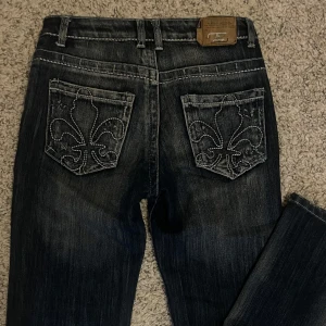 Mörkblå jeans med broderade bakfickor - Snygga mörkblå jeans från A. ring med unika broderade mönster på bakfickorna. bra skick.