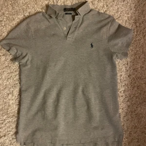 Grå pikétröja från Ralph Lauren - Säljer en stilren grå pikétröja från Ralph Lauren. Hör av dig vid frågor?