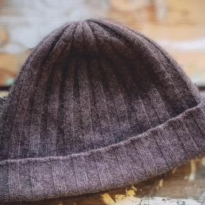 Brun ribbad mössa från Bläck - Snygg brun mössa från Bläck i kashmirblandning. Den har en ribbad design som ger en stilren look. Perfekt för kyliga dagar.