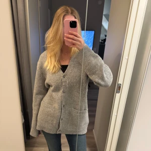 Grå kofta med knappar - Mysig grå kofta med knappar framtill och två fickor. Perfekt för kyligare dagar. Den har en avslappnad passform och långa ärmar. Är i storlek Xs men oversized så skulle säga storlek S/M