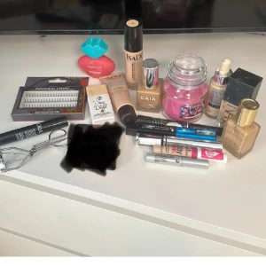 Blandat sminkset  - Ett sminkset med olika produkter inklusive foundation från IsaDora och CAIA, palett från PÜR, samt läppglans och mascara. Setet innehåller även en ögonfransböjare och individuella lösögonfransar. Perfekt för att skapa en komplett look. Det mesta är användt men fransarna och den rosa parfymen är helt nytt, maybiline, isadora och caia foundation är mer än halva kvar i!🥰