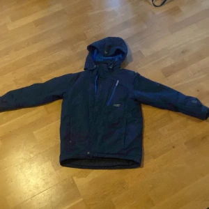Blå skidjacka från North Bend. - Säljer en blå skidjacka från north bed. Den har en ficka vid bröstet där man kan lägga sitt liftkort om man åker skidor. Jackan tjock och tätt, den är vattentät. Jackan är så gott som ny, har endast använt den en gång när jag åkte skidor i en helg. Väldigt skön, varm och perfekt om man ska åka lite skidor men funkar väldigt bra till mycket andra aktiviteter. Pris går att diskuteras. 
