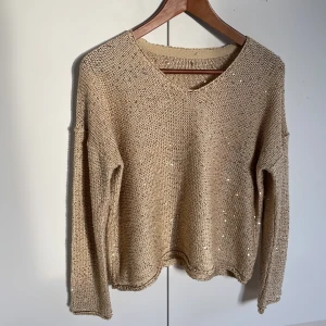 Guldig  stickad tröja med paljetter - Säljer en guldig paljett tröja som är köpt på second hand, storleken passar som M.