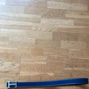 Blått skärp med silverfärgat spänne - Snyggt blått skärp med ett stilrent silverfärgat H-format spänne. Perfekt för att ge din outfit en elegant touch. Skärpet har en klassisk design och passar till många olika stilar.( Pris kan diskuteras )hskärp/svartbälte