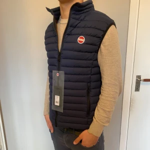 Mörkblå Colmar dunväst - Säljer en snygg mörkblå dunväst från Colmar | Storlek: 50, dvs small. Modellen är 178cm lång & väger 69kg | Västen är HELT NY med lapp kvar. 10/10 skick | Nypris 3200kr, vårat är 1525kr | Hojta till om du undrar över något :)