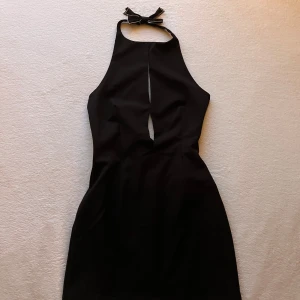 Zara svart klänning med rosett - Kort svart klänning från Zara med öppen rygg och glittrig rosett bakom nacken. Oanvänd 💗