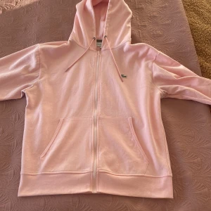 Rosa hoodie från Lacoste - Säljer en snygg rosa hoodie från Lacoste med dragkedja, använd några gånger men ser ny ut. Storlek M men passar S också. 
