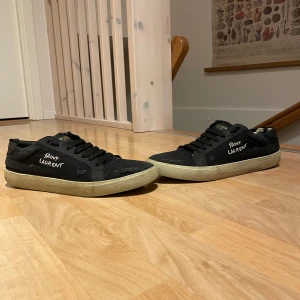 Saint Laurent Skor - Snygga svarta sneakers från Saint Laurent med vit logga på sidan. Skorna behövs dock renoveras lite, nya sulor och rusta upp gummisulan, annars funkar dom bra! Box kan fås med! 