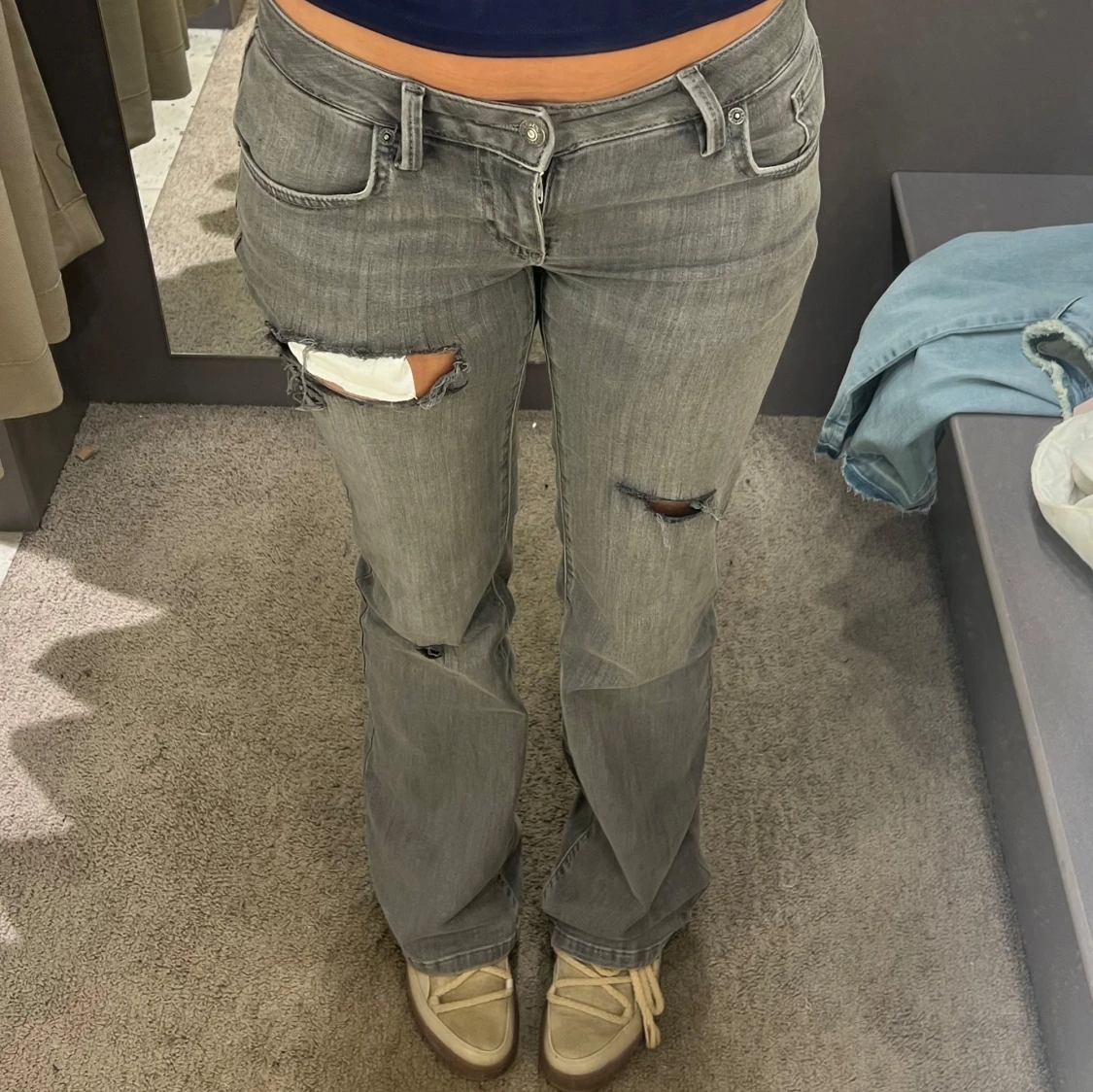 Grå jeans med slitningar