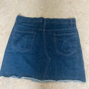 Jeanskjol - Snygg lågmidjad jeanskjol i mörkblå. Väldigt bra skick, nästan ny utan prislapp. Använd 1-2 gånger. Passar i längden på någon mellan ca 158-172 cm. 