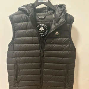 Svart Moose knuckels väst - Säljer min Moose knuckels väst köpte den för för 3 månader sedan men hann inte använda den innan de blev kyligt och nu passar den inte mig. Västen har inga skador eller slitningar.