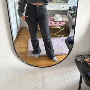 Svarta jeansbyxor - Snygga svarta jeansbyxor med hög midja och klassisk femficksdesign. Byxorna har en rak passform och stängs med dragkedja och knapp. Perfekta för en stilren look.