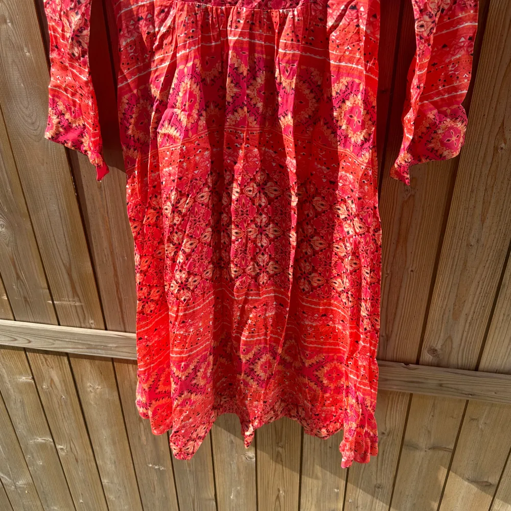 Säljer en färgglad röd klänning med ett unikt mönster. Klänningen har trekvartsärmar och en v-ringad hals med knytning. Perfekt för en bohemisk look. Från märket Odd Molly i storlek 0 som enligt deras storleksguide motsvarar en storlek XS. Mycket fint skick, jag hittar inga synliga anmärkningar eller defekter. . Mekot.