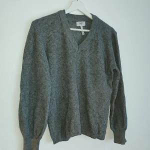 Grå ribbad tröja från Object - Säljer en stilren grå ribbad tröja från Object. Tröjan har en v-ringad design och långa ärmar, perfekt för kyligare dagar. Den är både bekväm och snygg, ett måste i garderoben!