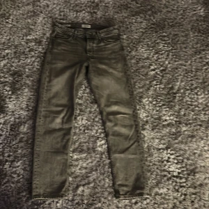 Grå jeansbyxor - Snygga grå jeansbyxor med en klassisk femficksdesign. De har en rak passform och är perfekta för en avslappnad stil. Byxorna har en dragkedja och knapp framtill. 