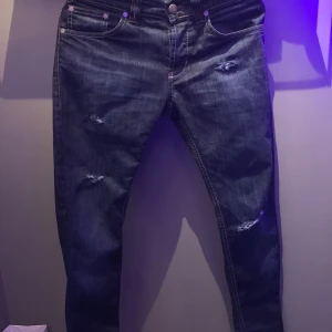 Blå dondup jeans med slitningar - Hej säljer nu mina dondups med slitningar jag säljer dom för att jag knappt använder dom och är knappt använda. Skriv vid frågor! Passar folk från 165-175🤩