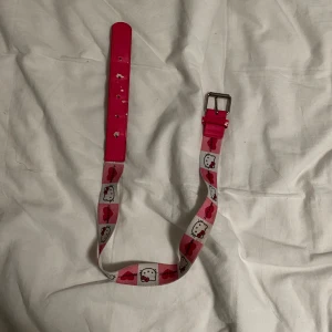 Hello Kitty bälte - Säljer ett supergulligt Hello Kitty bälte i rosa och vitt. Bältet är justerbart för att passa olika storlekar, men det är barnstorlek (passade inte mig, som använder xs). Perfekt accessoar för alla Hello Kitty-fans! 🐱💖