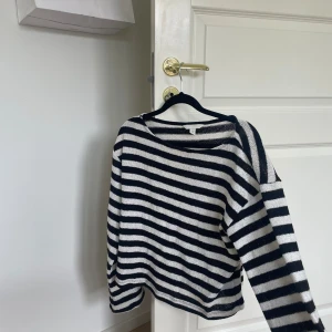 Randig tröja från H&M - Säljer en superfin randig tröja från H&M i storlek XS. Den är svart och vit med långa ärmar, perfekt för både höst och vår. Tröjan är i bra skick och passar till både jeans och kjol. Ett måste i garderoben för en stilren look!