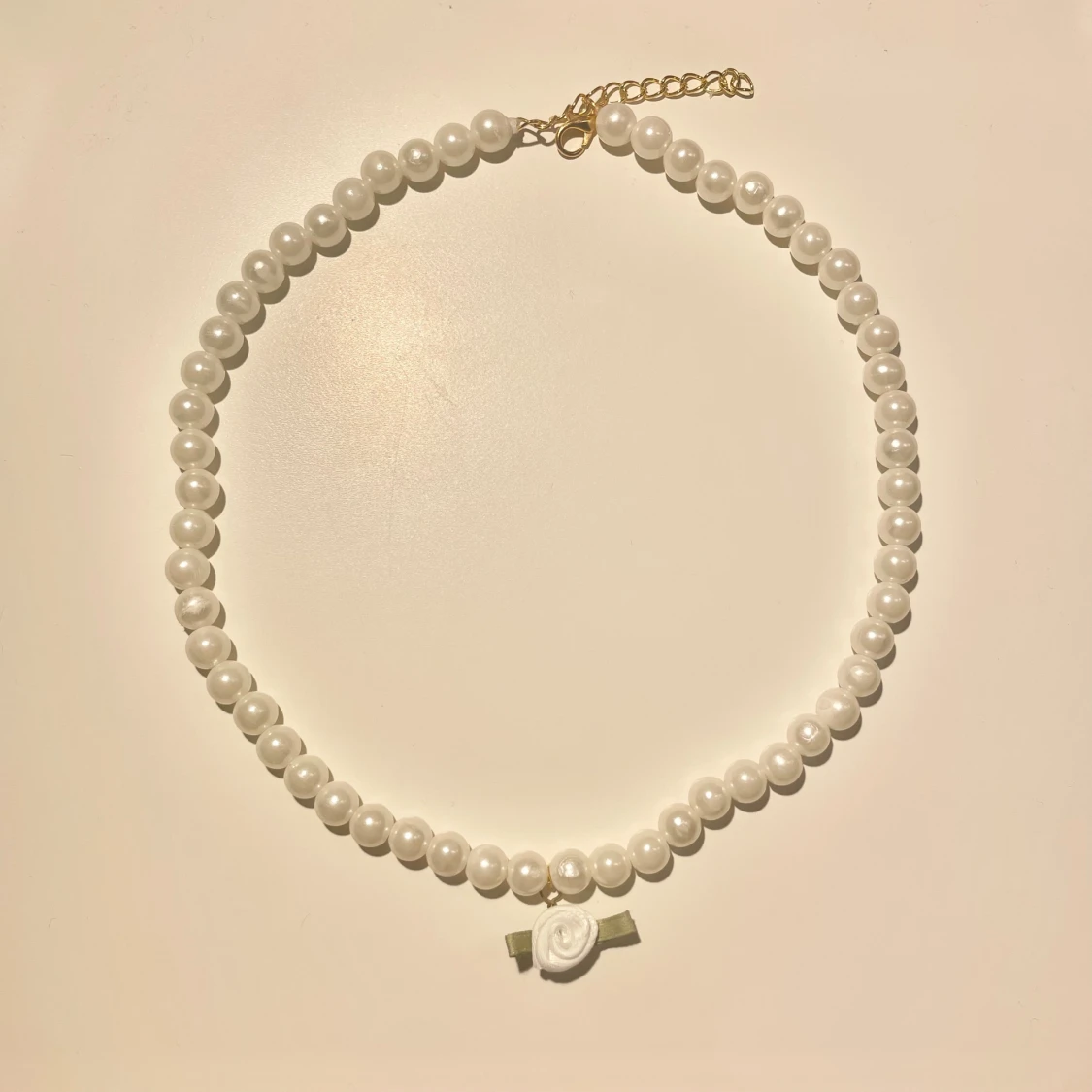 Pärlhalsband med vit rosdetalj