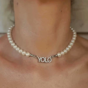 YOLO halsband (rostfritt stål)  - YOLO (you only live once) halsband med imiterade pärlor Material: Imiterade pärlor och rostfritt stål! Helt ny! Storlek:42 cm(justerbar)