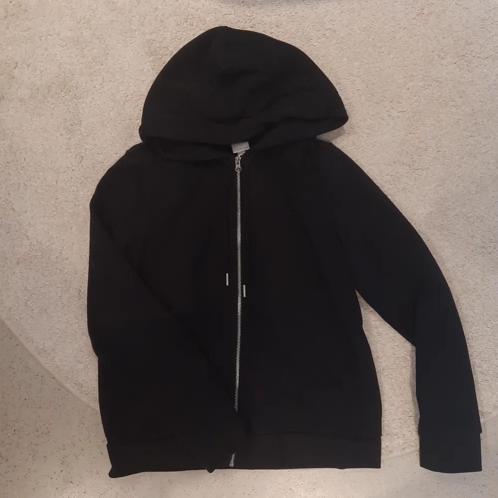 Säljer en svart zip-hoodie från H&M med fickor. Supermysig och passar till det mesta. Fint skick och inga större defekter, kan vara lite smånopprig bara, men kanppt något som syns eller man tänker på💕. Tröjor & Koftor.