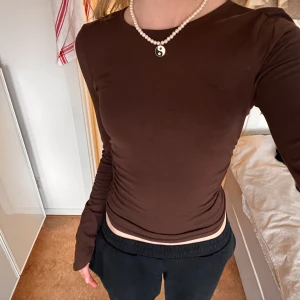 Långärmad topp Nelly - Så fin brun topp från Nelly! Har super superfina ärmar och rynkat tyg i midjan 💕 Skulle säga att den passar både xxs & xs!