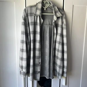 Mjuk tunn tröja med knappar - Mjukt tyg, lagom varm. Använt som jacka fåtal tillfällen. Väldigt bra skick. Grå rutig. 