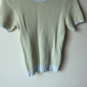 Mönstrad kortärmad tröja från Zara - Säljer en superfin kortärmad tröja från Zara i storlek M. Den har ett unikt mönster i ljusblått och gult, perfekt för vår och sommar. Tröjan är gjord i ett mjukt material och har ribbade kanter vid ärmar och nederkant. Perfekt för en casual look eller att klä upp med accessoarer!