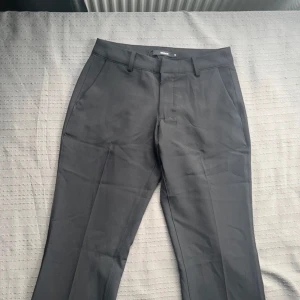 Lågmidjade kostymbyxor   - Säljer dessa snygga lågmidjade bootcut kostymbyxor med slits då dom inte kommer till användning. Helt nya, oanvända utan prislapp! Alltså är dom i ny skick. Har du frågor är det bara att skriva! 