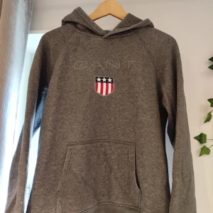 Mjukis tröja Gant  - Mörk grå mjukis tröja med luva i märket GANT. I fint skick.