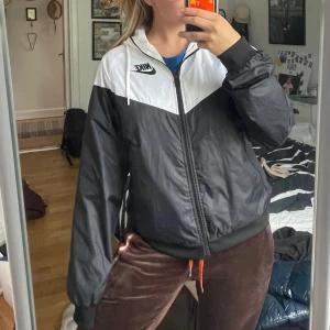 Nike vind jacka  - Säljer nu min Nike vind jacka då den ej kommer till användning. Fint skick och som ny. Har blivit lite gul vid kragen, men inget som syns när man har på sig den. 