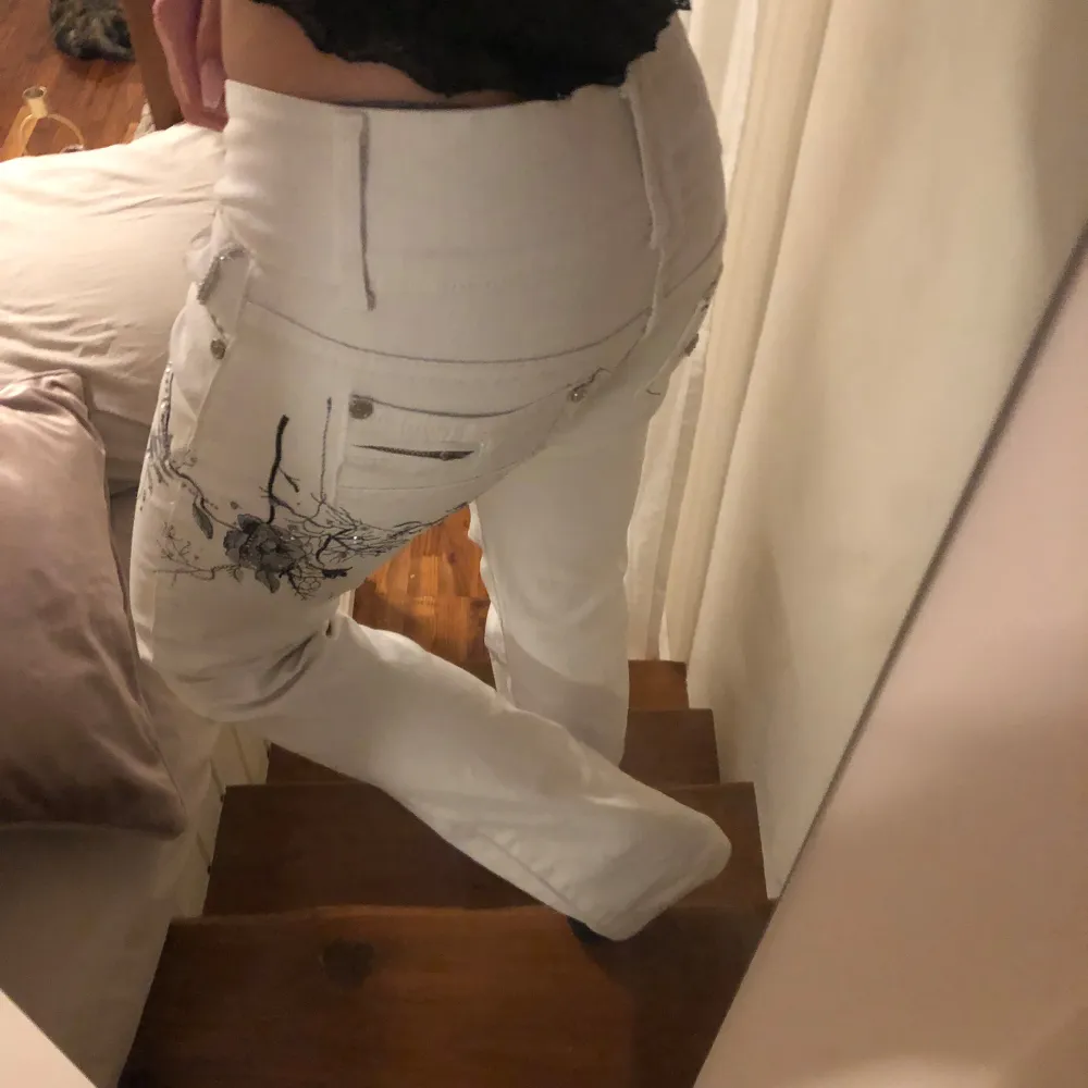 Säljer ett par vita jeans med snyggt Blom brodieri med diamanter på och diamant detaljer runt om fickorna i bak💗. Jeans & Byxor.