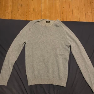 Grå tröja från Massimo Dutti - Säljer en stilren grå tröja från Massimo Dutti. Den är i bra skick och perfekt för både höst och vinter. Tröjan har långa ärmar och är gjord i ett mjukt material som känns skönt mot huden. Passar perfekt till både vardag och lite finare tillfällen. Priset är inte hugget i sten. Skriv för fler frågor/bilder.