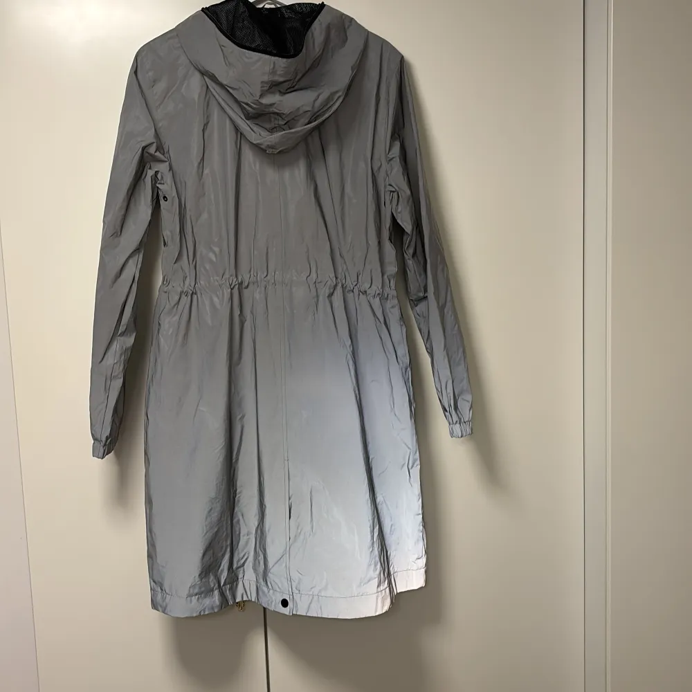 Säljer en stilren grå regnjacka från Lindex i storlek S. Jackan har en praktisk huva och dragkedja framtill. Perfekt för regniga dagar och har en snygg, enkel design. Passar bra till både vardag och utflykter. 🌧️. Takit.