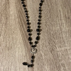 Svart pärlhalsband med hjärtdetalj - Snyggt svart halsband med pärlor och en söt hjärtdetalj i silver.