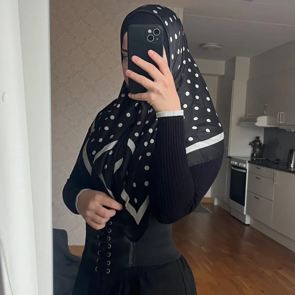 Snygg svart hijab med vita prickar och en stilren kant. . Accessoarer.