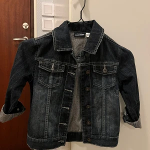 Svart jeansjacka från La Redoute - Säljer en snygg svart jeansjacka från La Redoute i bra skick. Jackan har en klassisk design med knappar framtill och två bröstfickor. Perfekt för vår och höst! 🖤