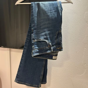 Blå jeans i bootcut-stil - Säljer ett par snygga blå jeans i bootcut-stil. De är i bra skick och har en klassisk blå färg som passar till allt.  De har en normal passform och är superbekväma. 
